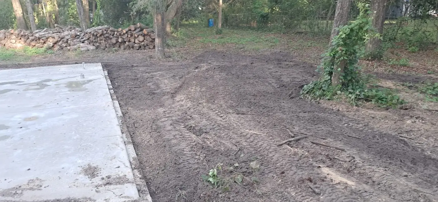 Freshly graded soil surrounding a concrete foundation on a wooded Florida property
